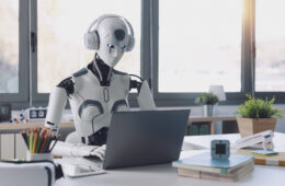 A humanoid robot works in an office on a laptop to listening Music in  Headphone, showcasing the utility of automation in repetitive and tedious tasks.