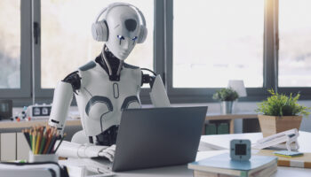 A humanoid robot works in an office on a laptop to listening Music in  Headphone, showcasing the utility of automation in repetitive and tedious tasks.