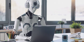 A humanoid robot works in an office on a laptop to listening Music in  Headphone, showcasing the utility of automation in repetitive and tedious tasks.